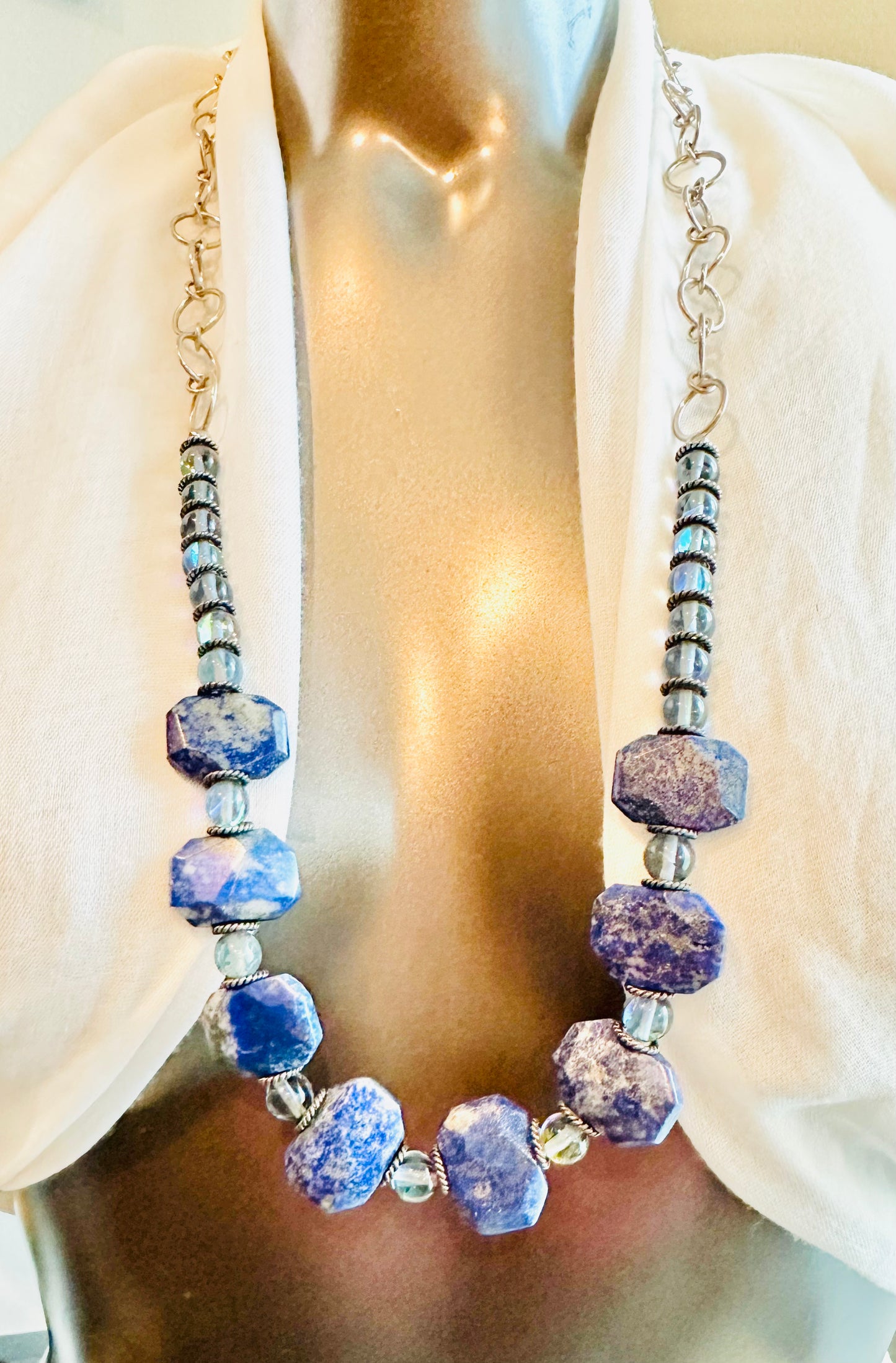 The pieces are crafted with care and feature a combination of gemstones, sterling silver, sodalite, and opalite.
The adjustable necklace measures between 14 to 24 in